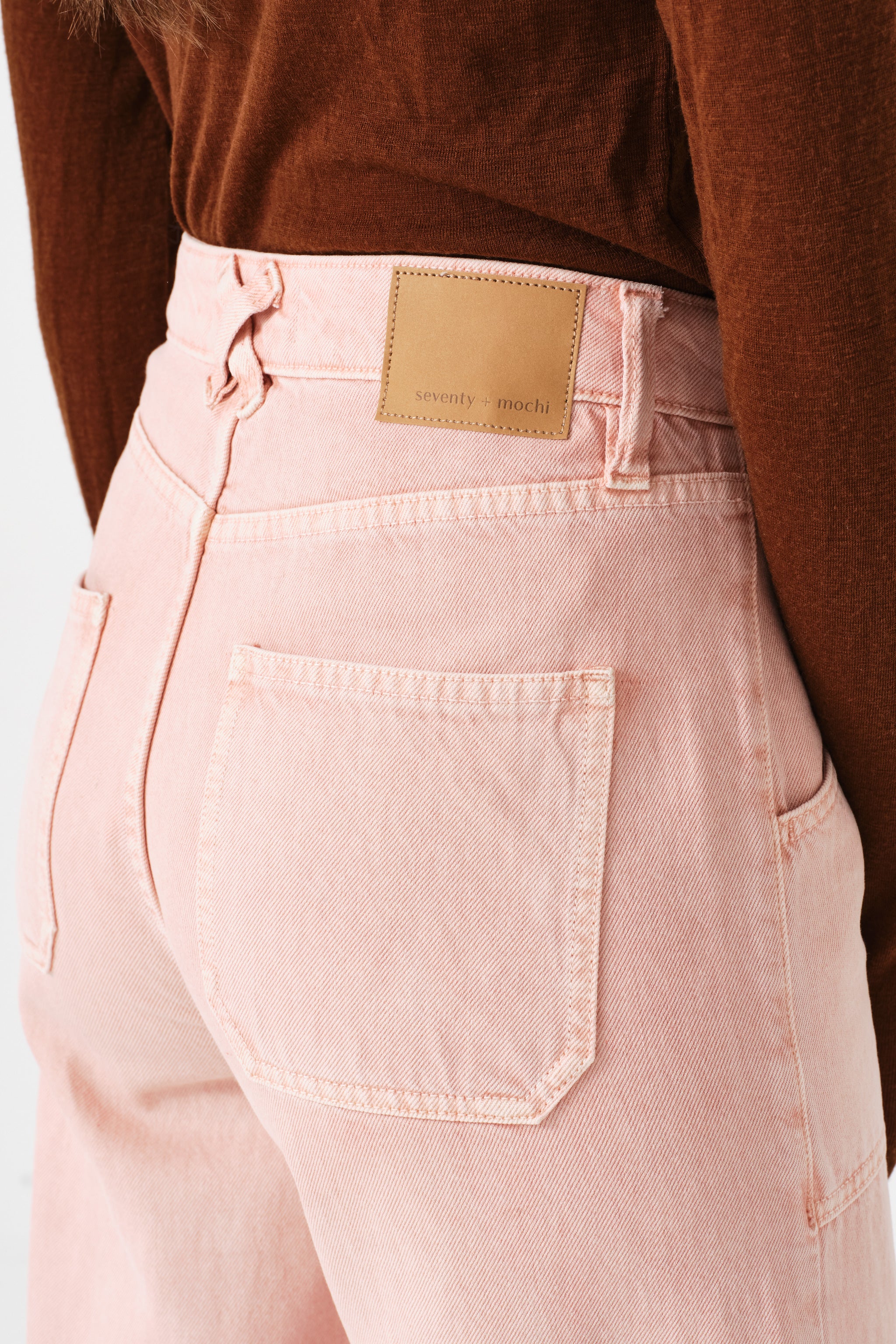 close up of woman wearing light pink high waisted, wide, cropped jeans with big pockets